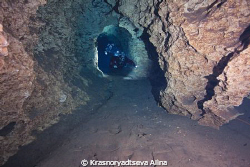 divers swimming along the tunnel of the Orange Grove Sink... by Krasnoryadtseva Alina 